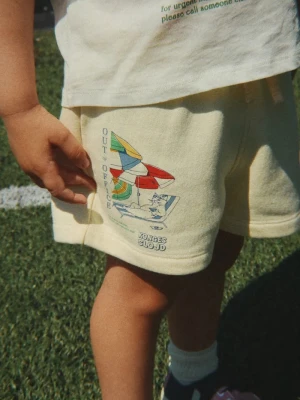 Obrázek produktu Konges Sløjd teplákové šortky dětské s bavlnou LOU SWEAT SHORTS OCS béžová