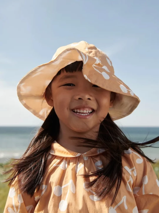 Obrázek produktu Liewood Dětský oboustranný klobouk Liewood Amelia Reversible Sun Hat oranžová